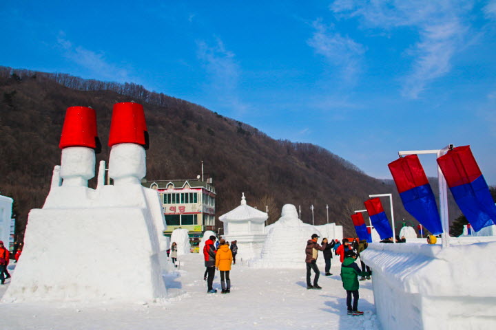 관광객들이 다양한 모양의 눈 조각상을 촬영하고 있다